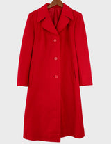 a woman is wearing a 90s vintage red coat.