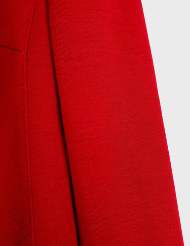 a woman is wearing a 90s vintage red coat.