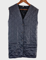 a woman is wearing a silver quilted vest.