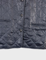 a woman is wearing a silver quilted vest.