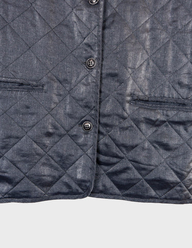 a woman is wearing a silver quilted vest.