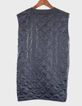 a woman is wearing a silver quilted vest.