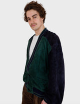 a man is wearing a 80s vintage green jacket.