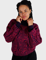 a woman is wearing a 80s dark pink geometric turtleneck sweater.