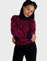 a woman is wearing a 80s dark pink geometric turtleneck sweater.