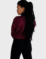 a woman is wearing a 80s dark pink geometric turtleneck sweater.
