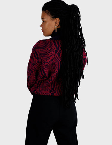 a woman is wearing a 80s dark pink geometric turtleneck sweater.