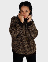 a woman is wearing a brown sweater.