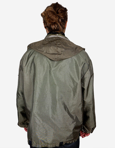a woman is wearing a olive green jacket.
