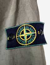 a woman is wearing a olive green jacket.