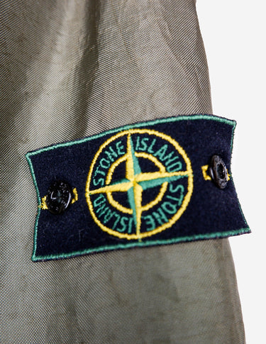 a woman is wearing a olive green jacket.