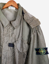 a woman is wearing a olive green jacket.