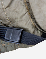 a woman is wearing a olive green jacket.