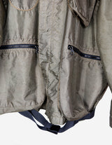 a woman is wearing a olive green jacket.
