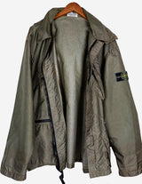 a woman is wearing a olive green jacket.
