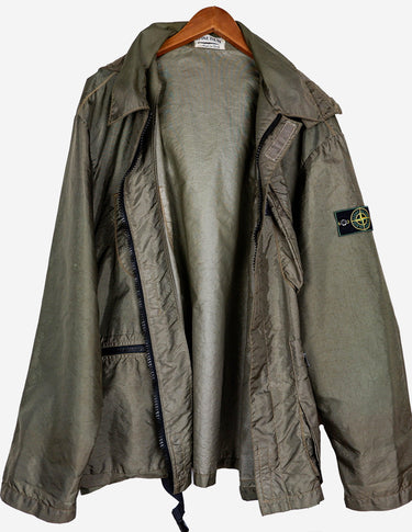 a woman is wearing a olive green jacket.