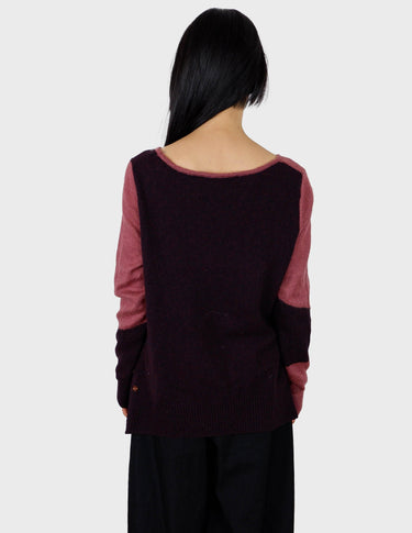 an asian woman is wearing a pink sweater.