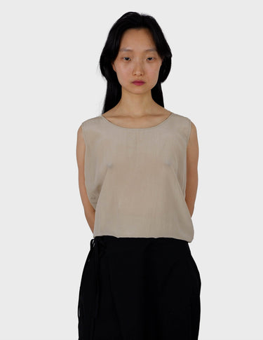 a woman is wearing a beige vintage 90s silk top.