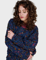 a woman is wearing a handknitted sweater.