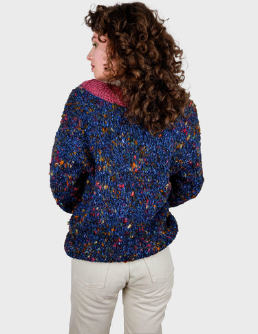 a woman is wearing a handknitted sweater.
