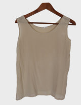 a woman is wearing a beige vintage 90s silk top.