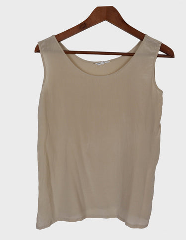 a woman is wearing a beige vintage 90s silk top.
