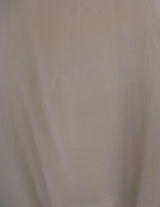 a woman is wearing a beige vintage 90s silk top.