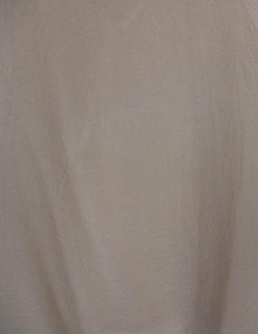 a woman is wearing a beige vintage 90s silk top.