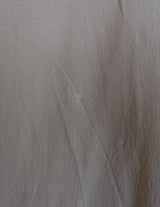 a woman is wearing a beige vintage 90s silk top.
