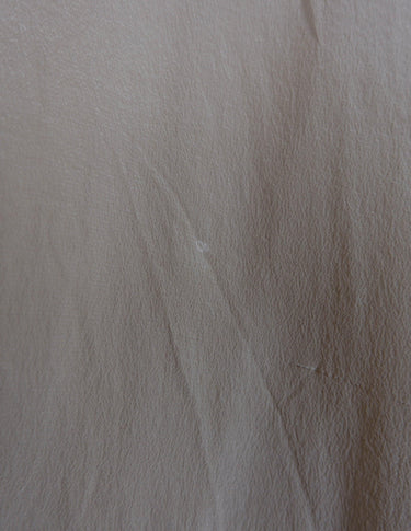 a woman is wearing a beige vintage 90s silk top.