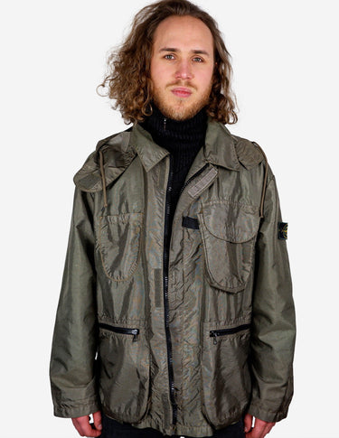 a woman is wearing a olive green jacket.