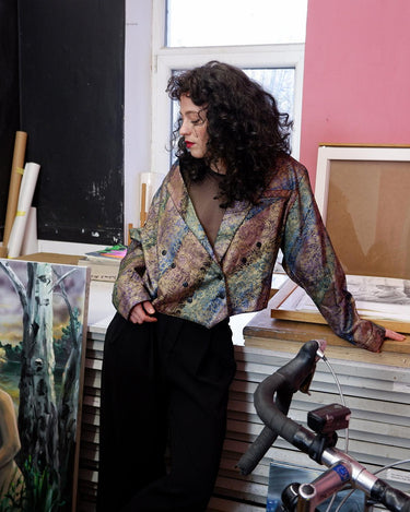 This vintage '80s blazer is sure to make a statement! Cropped and lightweight with an eye-catching, floral shimmer pattern, this funky piece of fashion will be sure to bring some drama to your look. Throw it on with shoulder pads for added edge (removable shoulder pads).