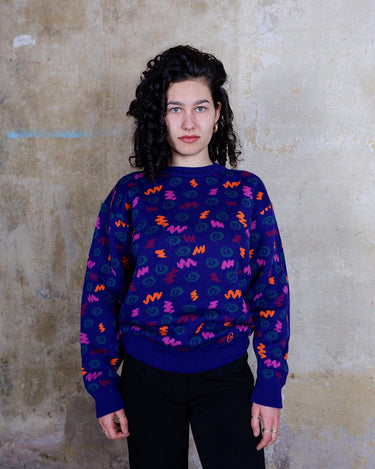 Embrace this eye-catching purple sweater from the 90s. With its unique multi-color pattern, it's sure to bring some pop of personality to your outfit.