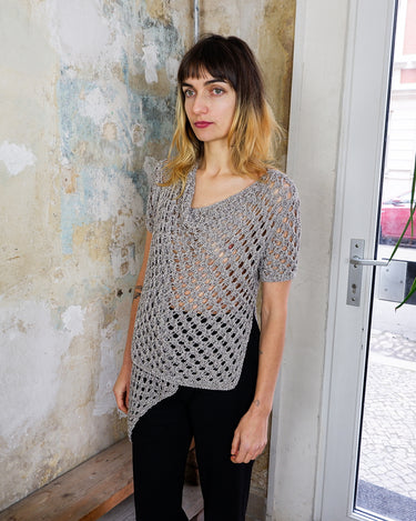 Preloved and handmade, this silver crochet top catches the light with its soft shimmer. The open-knit design and asymmetrical cut give it that effortless, worn-in feel. A rare find that’s easy to style and full of character.