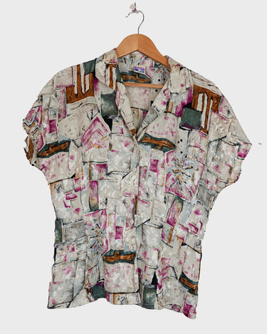 Look your wildest in our Crazy pattern short sleeve light shimmering blouse! This tailored fit gives you a sleek silhouette that shimmers in the light! Featuring a unique pattern, you'll be making an elegant statement everywhere you go! Shimmy on!
