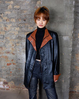 Bring some edge to your wardrobe with this lightweight and very thin vintage 80s black leather jacket - perfect for spring and summer nights! The brown accents add a touch of contrast, while the convenient zipper and press buttons allow for versatile styling. What are you waiting for?