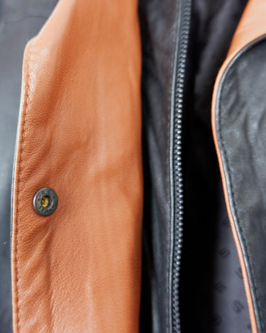 Bring some edge to your wardrobe with this lightweight and very thin vintage 80s black leather jacket - perfect for spring and summer nights! The brown accents add a touch of contrast, while the convenient zipper and press buttons allow for versatile styling. What are you waiting for?