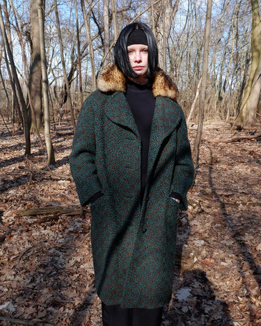 Experience true vintage elegance with this stunning green wool coat from the 70s/80s. Beautiful brown accents add a stylish touch, while the real fur collar adds a luxurious and statement-making element.