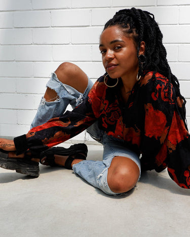 This vintage 80s velvet x silk blouse is having a moment! Its flowy and lightweight transparent fabric, coupled with its stunning red floral pattern, make it a must-have!