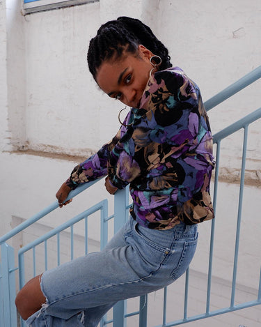 Flower power! This vintage, floral-patterned blouse is made from pure silk, and features dramatic shoulder pads and a button row at the back. Experience '80s elegance with a modern twist! #teamshoulderpads