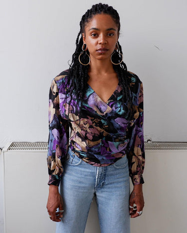 Flower power! This vintage, floral-patterned blouse is made from pure silk, and features dramatic shoulder pads and a button row at the back. Experience '80s elegance with a modern twist! #teamshoulderpads