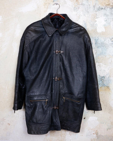 Introducing this Vintage 80s black fireman clasp leather coat, a must-have piece for your collection. Made of buttery soft leather, this coat exudes a cool and edgy vibe.