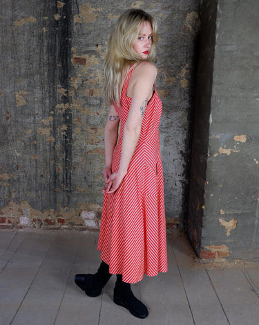 Get ready to add some fun to your wardrobe with this Vintage 80s red yellow striped a-form dress! This playful dress features bold stripes in bright colors, short sleeves, and button detailing.