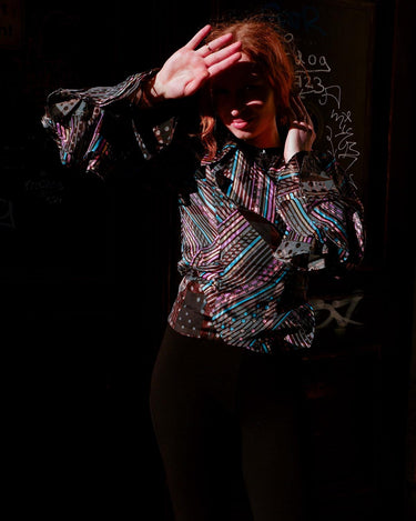Get ready to make a statement with this vintage 80s transparent wrap blouse! The unique volant sleeves add a touch of playfulness to this colorful piece.