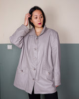 This grey spring coat combines vintage vibes with shoulder pads for a touch of 80s flair.