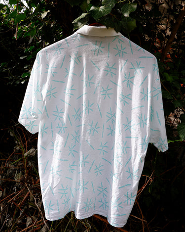 Sun’s out, button up! This Italian vintage white polo shirt brings serious 80s energy with its sharp button-up neckline and eye-catching turquoise pattern. A rare vintage gem that’s equal parts sporty, stylish, and a little cheeky. Wear it loud, wear it proud – this polo’s got main character energy.