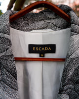 Make a statement with this vintage Escada blazer—bold, tailored, and anything but ordinary. Its detailed monochrome botanical print and iconic Escada cut turn timeless elegance into something effortlessly cool. A rare secondhand gem for lovers of slow fashion and sharp silhouettes, this piece brings instant edge to any outfit. Vintage luxury, with attitude.