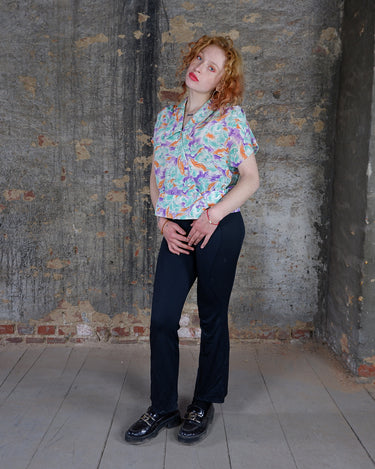 Add a pop of color to your wardrobe with this Vintage 80s colorful short sleeve blouse! Its diagonal button row adds a unique touch, and the lightweight fabric ensures comfort all day long. A fun and playful addition to any outfit.