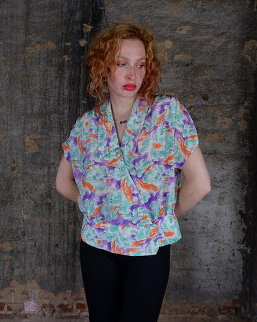 Add a pop of color to your wardrobe with this Vintage 80s colorful short sleeve blouse! Its diagonal button row adds a unique touch, and the lightweight fabric ensures comfort all day long. A fun and playful addition to any outfit.