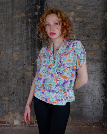 Add a pop of color to your wardrobe with this Vintage 80s colorful short sleeve blouse! Its diagonal button row adds a unique touch, and the lightweight fabric ensures comfort all day long. A fun and playful addition to any outfit.